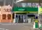 Pawilon sklepowy stacji BP w Łodzi z wejściem do sklepu, strefą Wild Bean Cafe, miejscem parkingowym dla osób z niepełnosprawnością i dystrybutorem paliwa.